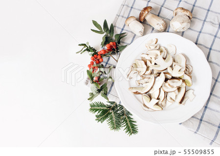 Autumn food arrangement. Composition of whole and sliced porcino mushrooms, ceps on plate. Rowan 55509855