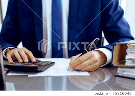Bookkeeper or financial inspector hands making report, calculating or checking balance. Internal Bookkeeper or financial inspector hands making report, calculating or checking balance. Internal 55510040