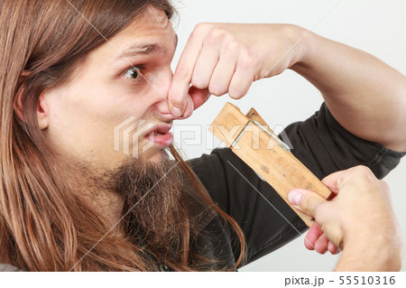 Man with clogged nose by clothespin 55510316