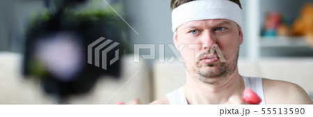 Serious Vlogger Doing Exercise with Dumbbells 55513590