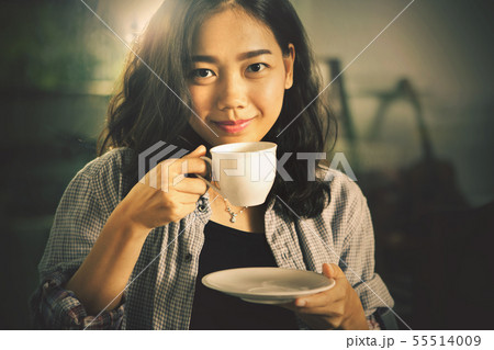 asian younger woman  drinking hot coffee in white 55514009