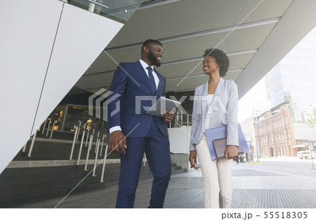 Two african american colleagues discussing new project outdoors Two african american colleagues discussing new project outdoors 55518305