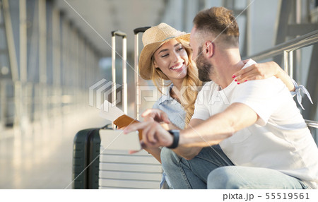 Loving couple in airport using travel app on smartphone 55519561
