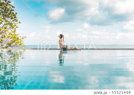 Woman relaxing in yoga over the pool on beach 55521439