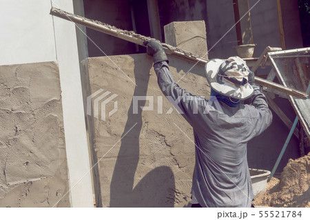 Construction workers plastering building wall 55521784