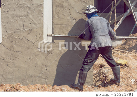 Construction workers plastering building wall Construction workers plastering building wall 55521791