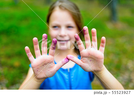 little girl is showing the blueberry-colored hands 55523927