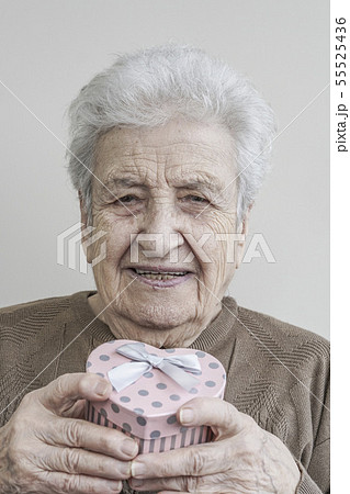 senior woman holding heart shaped gift senior woman holding heart shaped gift 55525436