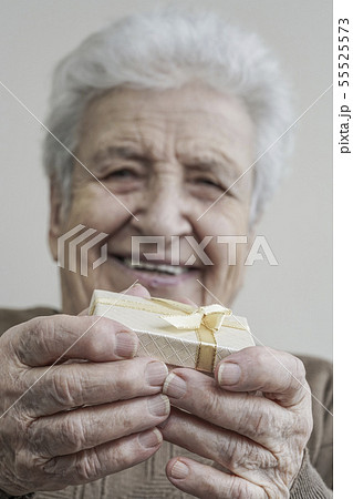 senior woman holding gift on her hands 55525573