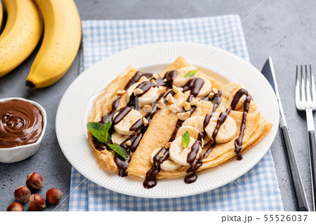 Tasty crepe with banana and chocolate sauce 55526037