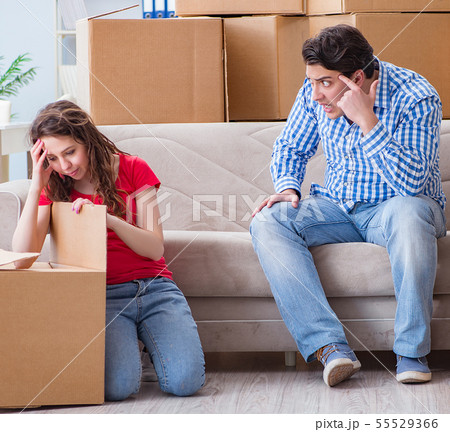 Young pair moving in to new house with boxes Young pair moving in to new house with boxes 55529366