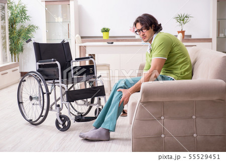 Young male invalid in wheelchair suffering at home 55529451