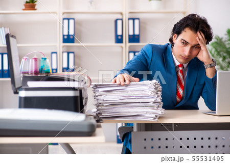 Young employee making copies at copying machine 55531495