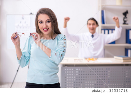Young woman visiting male doctor oculist Young woman visiting male doctor oculist 55532718