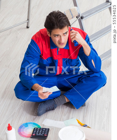 Young painter trying to match colours for painting job 55534025