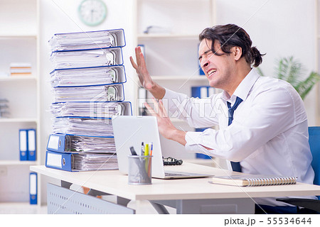 Young male employee unhappy with excessive work 55534644