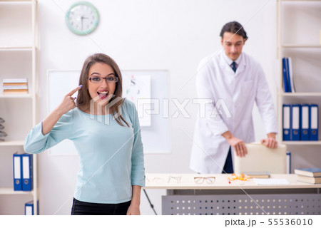 Young woman visiting male doctor oculist 55536010