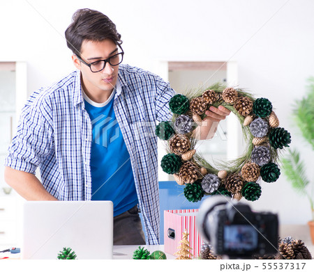 Young vlogger recording video doing christmas decoration 55537317