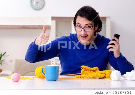 Young good looking man knitting at home 55537351