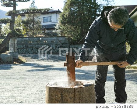 An older man making mochi in the winter 55538239