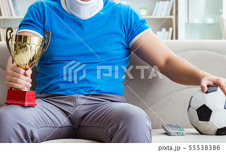 Man with neck injury watching football soccer at home Man with neck injury watching football soccer at home 55538386