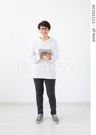 Technologies and modern people concept - Beautiful woman 50 years old with short hair holding tablet 55539236