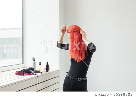 Beautiful red-haired girl with long hair, she is weaves a braid, in a beauty salon. Professional Beautiful red-haired girl with long hair, she is weaves a braid, in a beauty salon. Professional 55539505