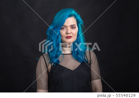 Style and fashion concept - Young and attractive woman with blue hair posing over black background Style and fashion concept - Young and attractive woman with blue hair posing over black background 55540129