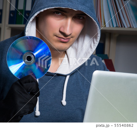 Young hacker hacking into computer at night Young hacker hacking into computer at night 55540862