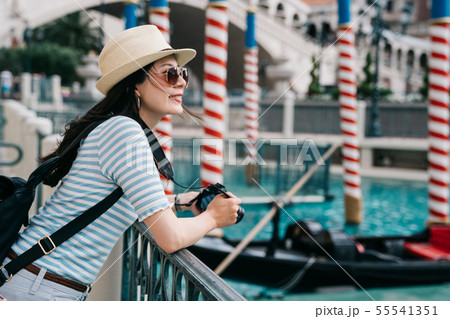 photographer holding camera leaning on bridge photographer holding camera leaning on bridge 55541351