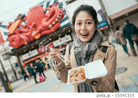 takoyaki in box on hands of young happy woman 55541355