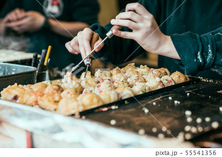 hands in process cooking takoyaki on hot pan 55541356