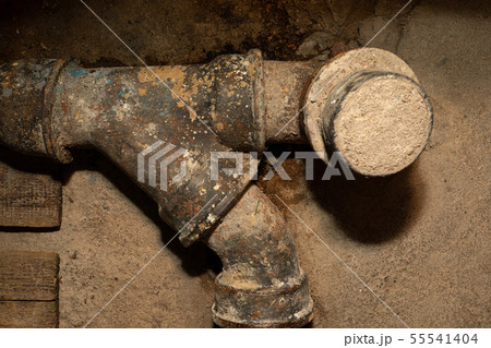 Worn out rusty water pipe in a concrete wall Worn out rusty water pipe in a concrete wall 55541404
