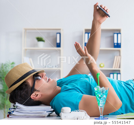 Businessman preparing for vacation in the office Businessman preparing for vacation in the office 55541547