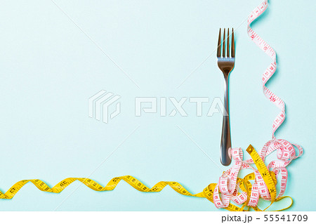 Top view composition of fork and curled measuring Top view composition of fork and curled measuring 55541709