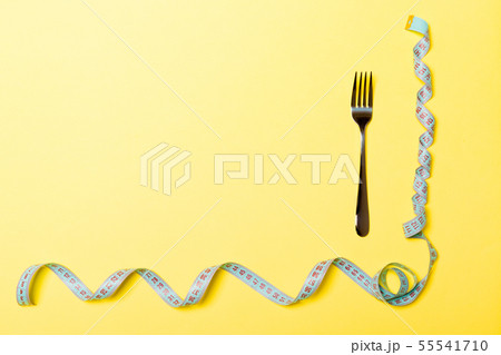 Top view of fork and curled measuring tape on Top view of fork and curled measuring tape on 55541710