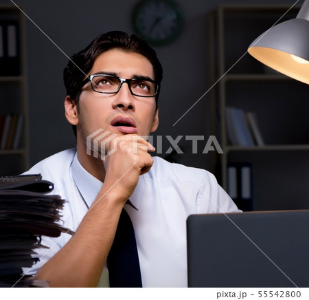 Young businessman working overtime late in office 55542800