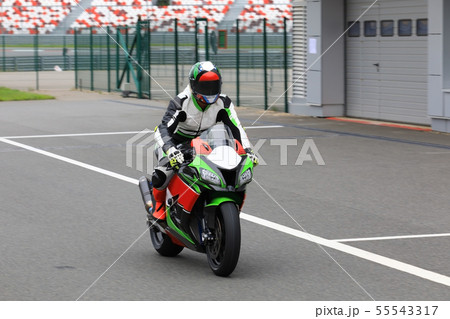 Motorcyclist on a racing motorcycle back to the Motorcyclist on a racing motorcycle back to the 55543317