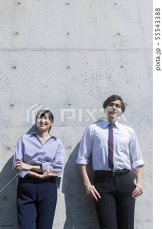 コンクリートの壁の前に立つ男女 コンクリートの壁の前に立つ男女 55543388