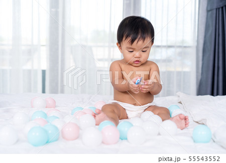 baby sitting on bed 55543552