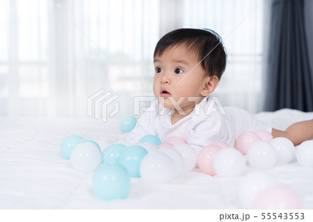 cheerful baby playing color ball on bed cheerful baby playing color ball on bed 55543553