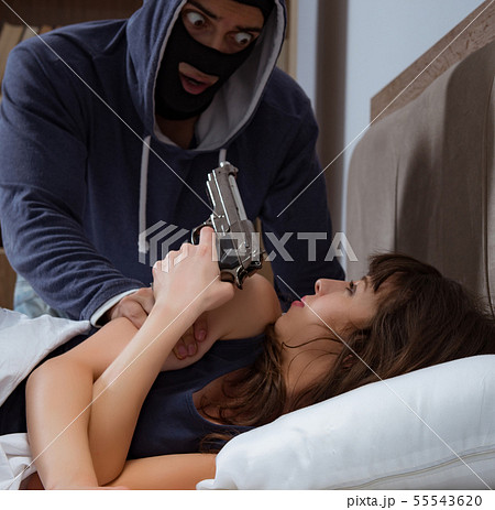 Burglar breaking into house at night to bedroom with sleeping wo 55543620