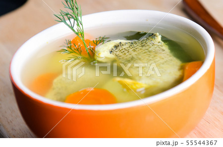 Fish soup served on the table in plate 55544367