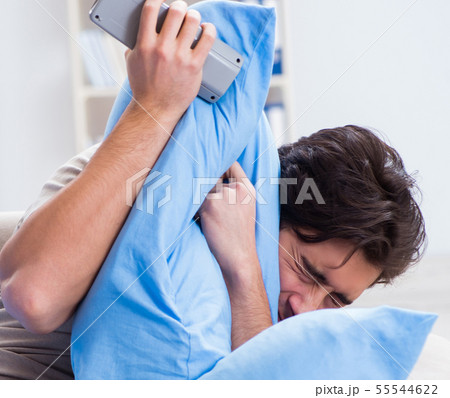 Man watching tv from bed holding remote control unit Man watching tv from bed holding remote control unit 55544622