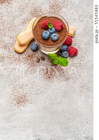 Classic tiramisu dessert with blueberries and raspberries and savoiardi cookies in a glass on Classic tiramisu dessert with blueberries and raspberries and savoiardi cookies in a glass on 55545983