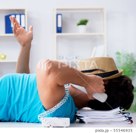 Businessman preparing for vacation in the office Businessman preparing for vacation in the office 55546935
