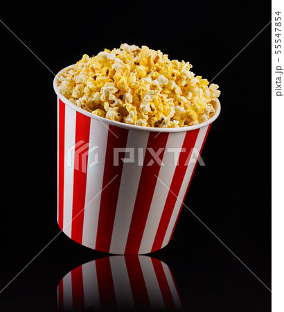 Paper striped bucket with popcorn isolated on black background 55547854