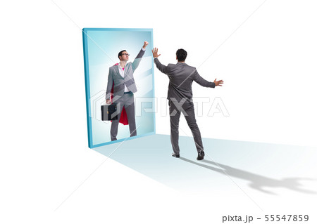 Businessman seeing himself in mirror as superhero 55547859