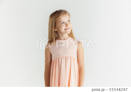 Little smiling girl posing in dress on white studio background Little smiling girl posing in dress on white studio background 55548297