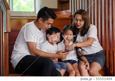 happy asian Family watching video on mobile phone happy asian Family watching video on mobile phone 55551404